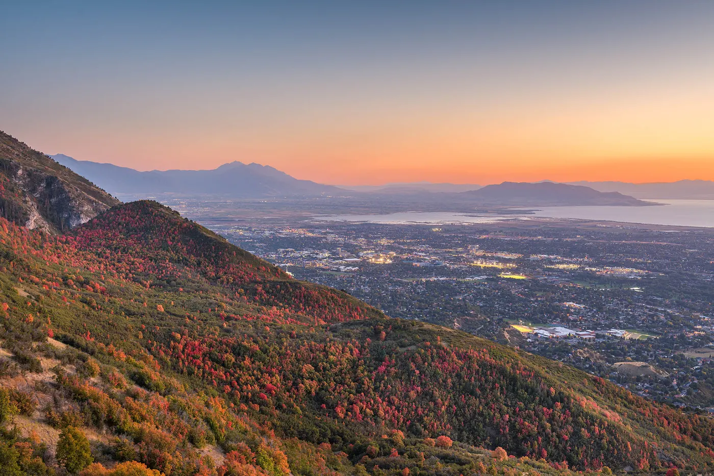 Autumn mountainside overlooking Salt Lake Valley at sunset with distant lake