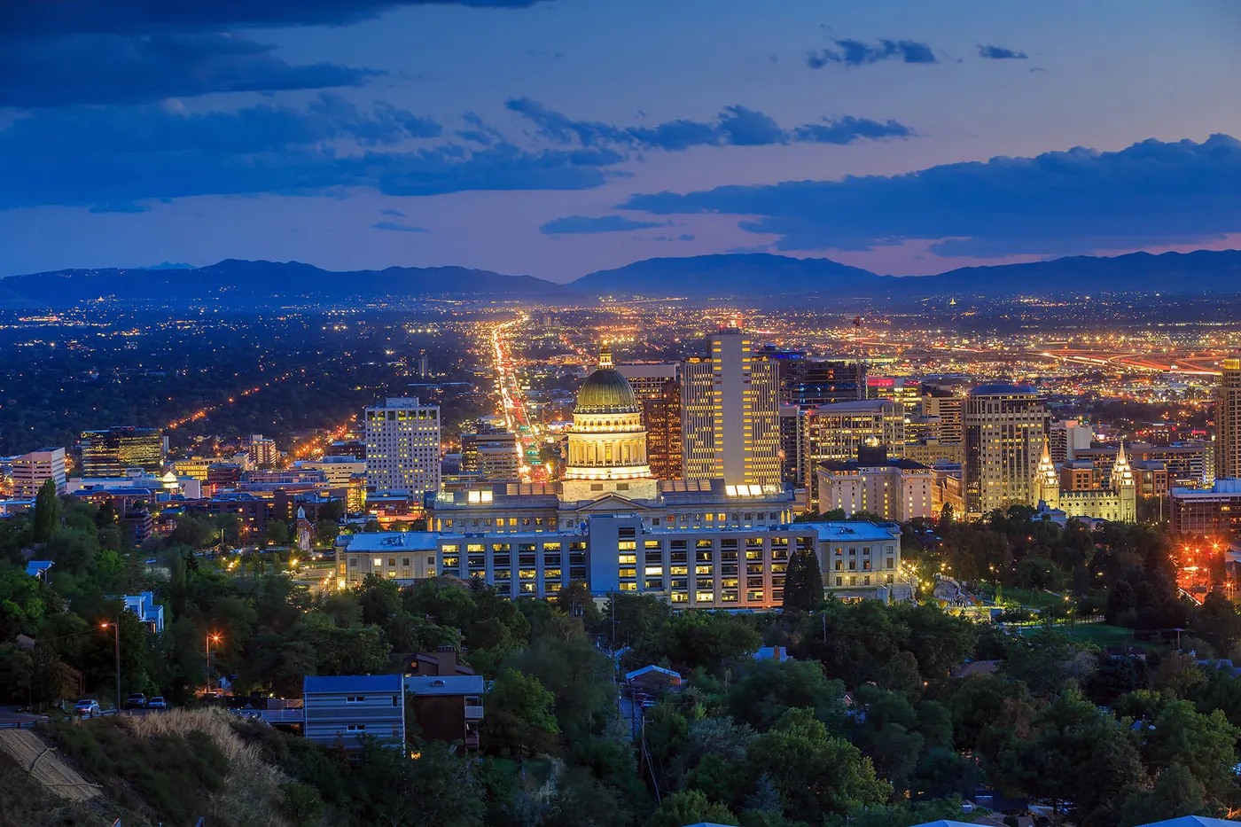 Salt Lake City skyline at dusk with Utah State Capitol and mountain backdrop